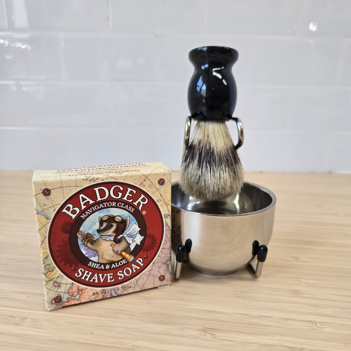 Shaving brush and stand with Badger Balm jar on a wooden surface
