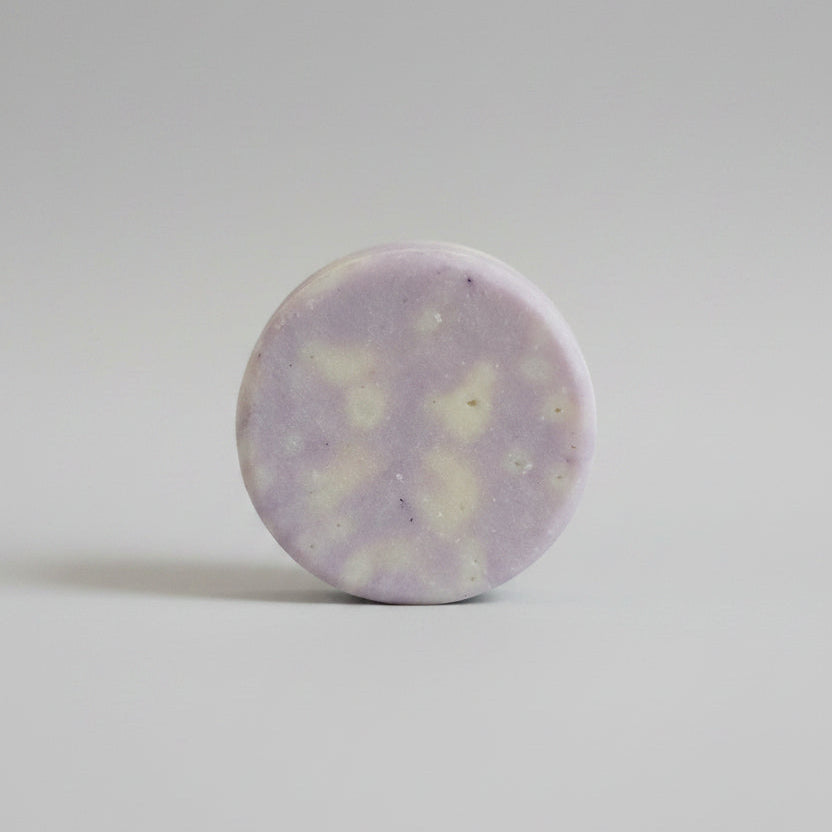Close-up of a round, light-colored stone on a textured beige surface