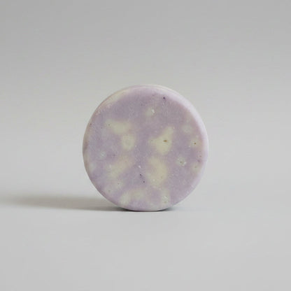 Close-up of a round, light-colored stone on a textured beige surface