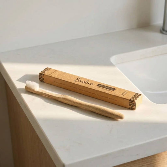 Bamboo toothbrush and packaging on a white countertop