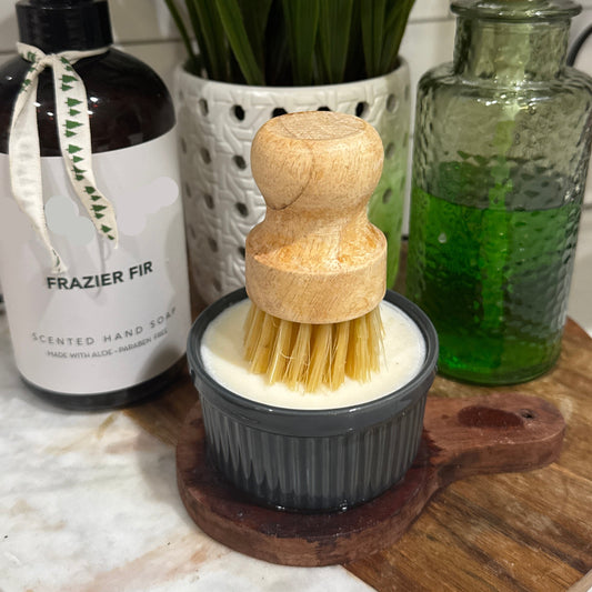 solid dish soap in a ramekin with a wood handle scrub brush.