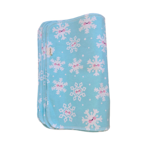 A blue cloth towel with a pattern of snowflakes and a visible brand tag on the corner.
