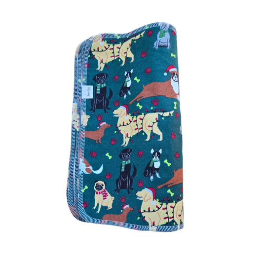 A square-shaped, green paper towel with a pattern of various dogs and Christmas-themed illustrations.