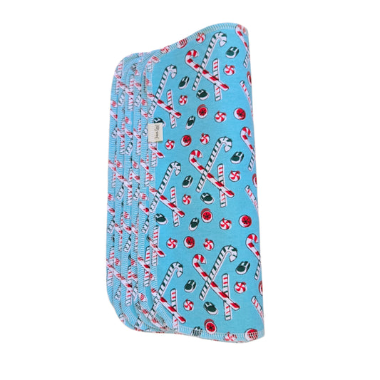 A blue cotton towel with a Christmas-themed pattern, including holiday ornaments and the text 'zzPAPERLESS TOWELS'.